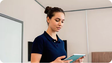 Housekeeper using a digital tablet to inspect a bedroom at a fly-in fly-out accommodation facility.