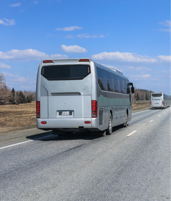 Charter buses drive down barren road