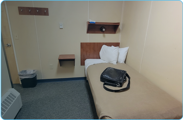 Vacant bedroom with a bag placed on bed in a remote FIFO camp.