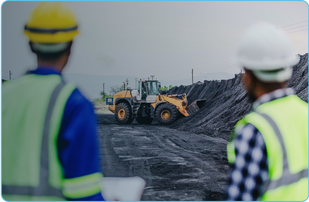 Mining workers look on to bulldozer in open pit mine.