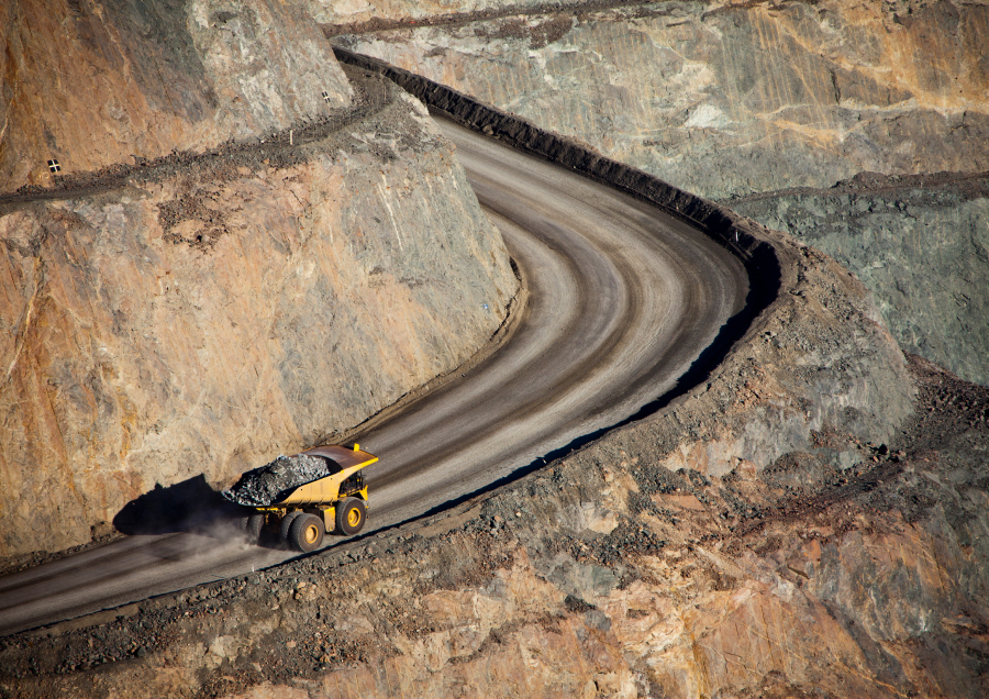 Haul truck drives up hill in open pit mine