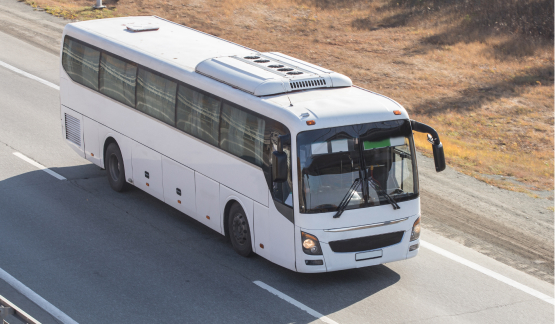 Charter bus driving down a highway, transporting workers to a remote oil and gas project.