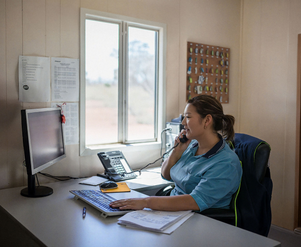 Front desk agent working at a remote camp reception desk.