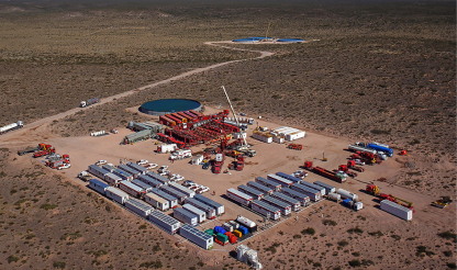 Onshore drilling rig in a remote location in Argentina, surrounded by equipment and housing facilities.