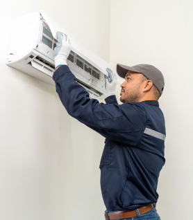 Maintenance staff reviews internal functioning of air conditioning unit.