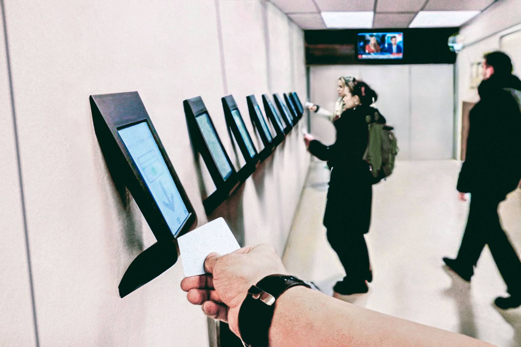 Person taps a electronic keycard at a kiosk awaiting activation of the card.