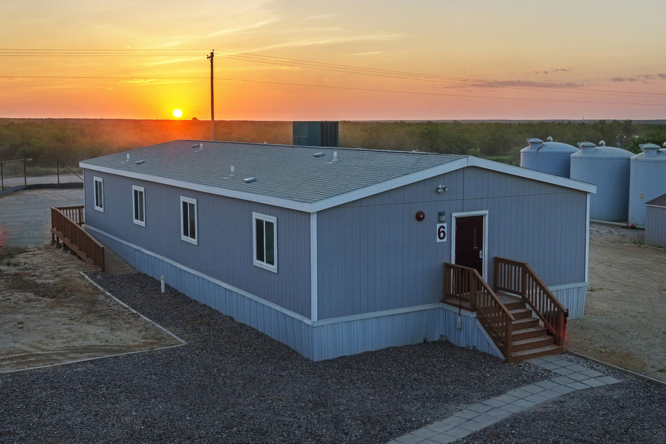 Portable modular structure built for worker housing in Texas at sunset.
